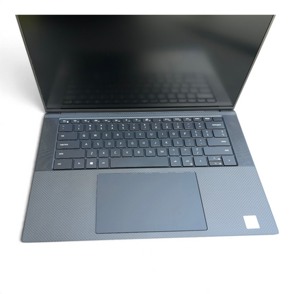 The Computer Market Dell Precision 5550 laptop with a black keyboard and carbon fiber palm rest, top-down view.